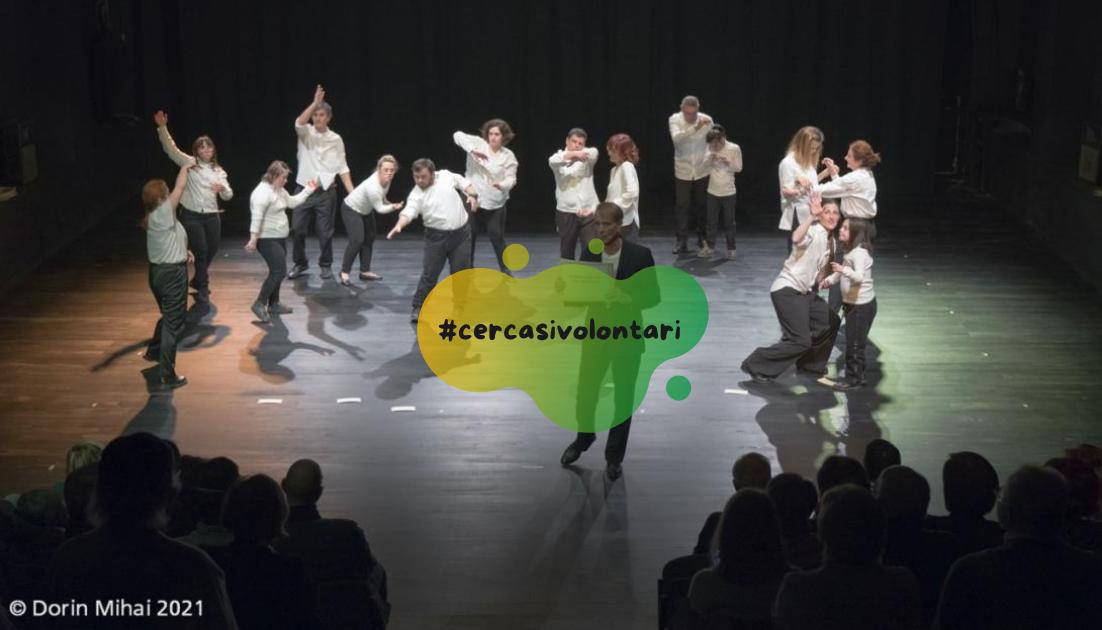 collettivo-diversamente-danzanti Foto del gruppo di danzatori sul palco, vestiti con camicia bianca e pantalone scuro
