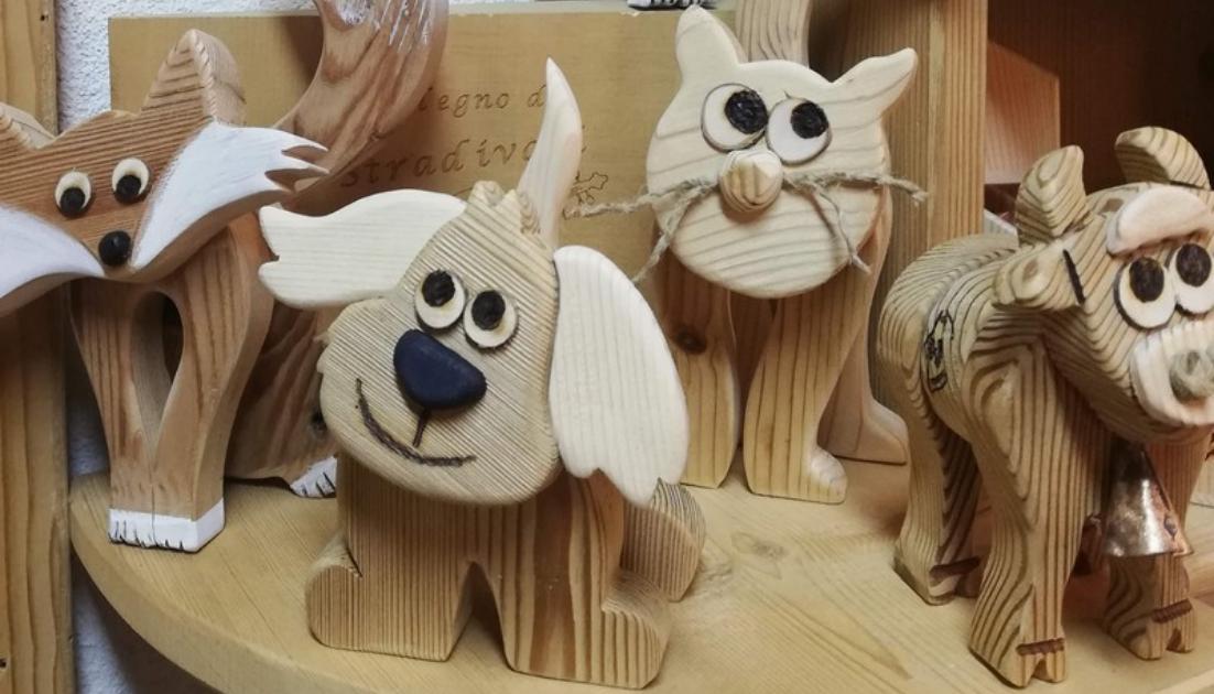 laboratorio-falegnameria Sculture artigianali in legno disposte su ripiano, a forma di cane, gatto, volpe e mucca